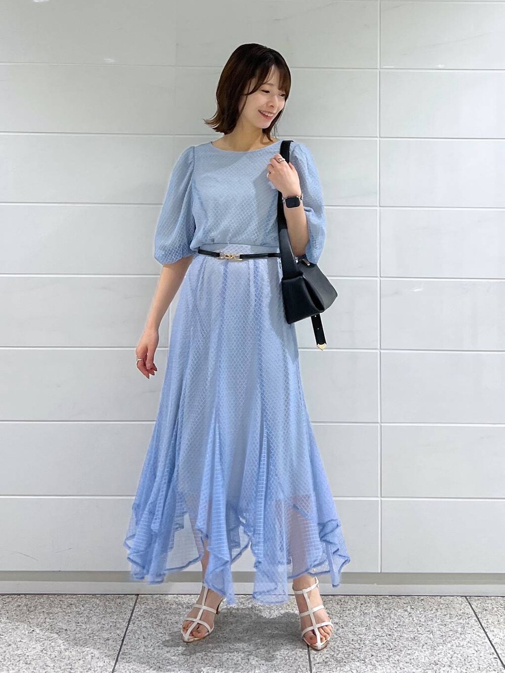 ブラック系のショルダーバッグ、ホワイト系のサンダル、ブルー系のスカートを着用したレディースの夏コーディネートの1枚目の写真