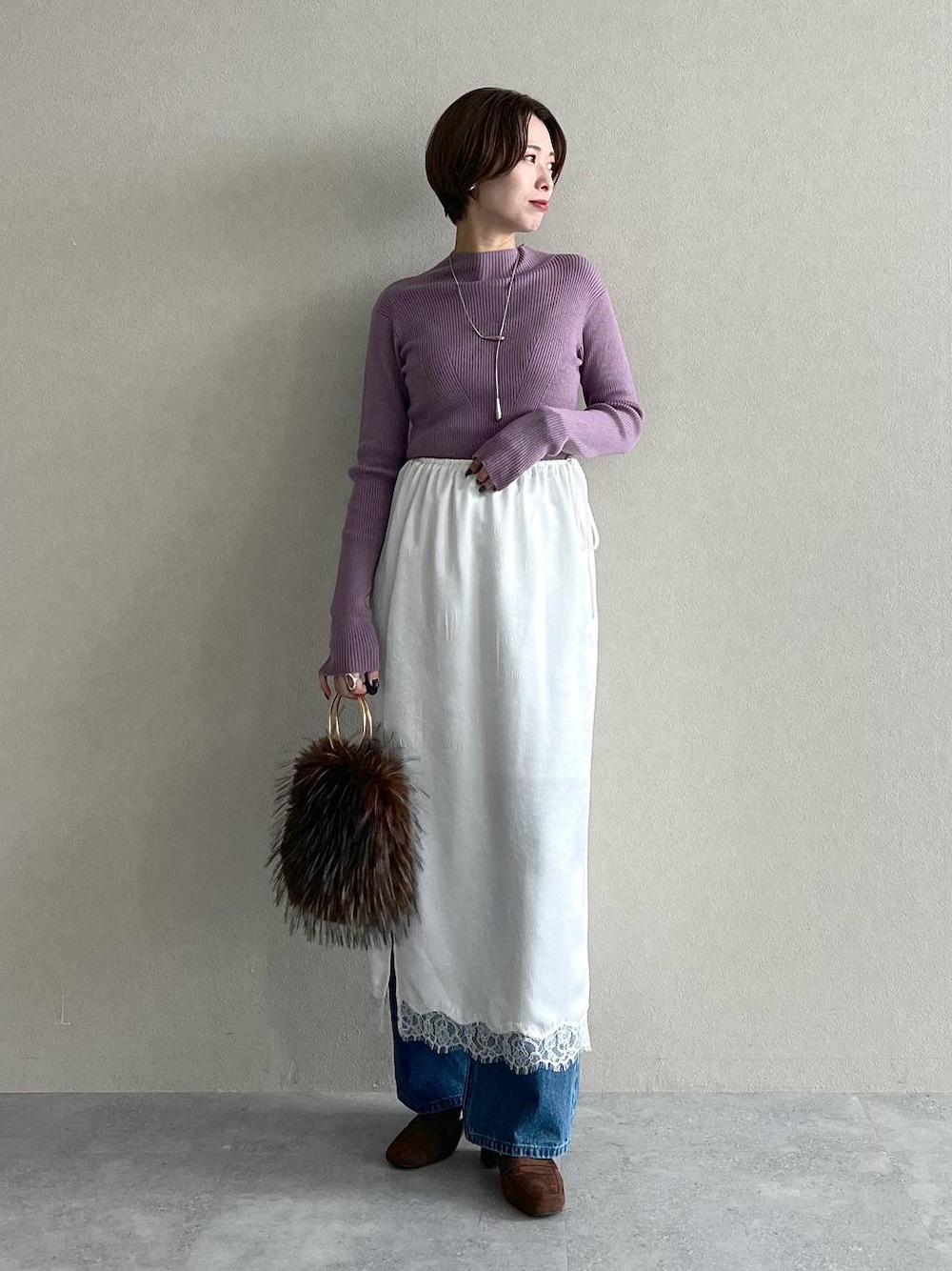 パープル系のニット/セーター、ブルー系のデニムパンツ、ブラウン系のローファーを着用したレディースの秋コーディネートの1枚目の写真