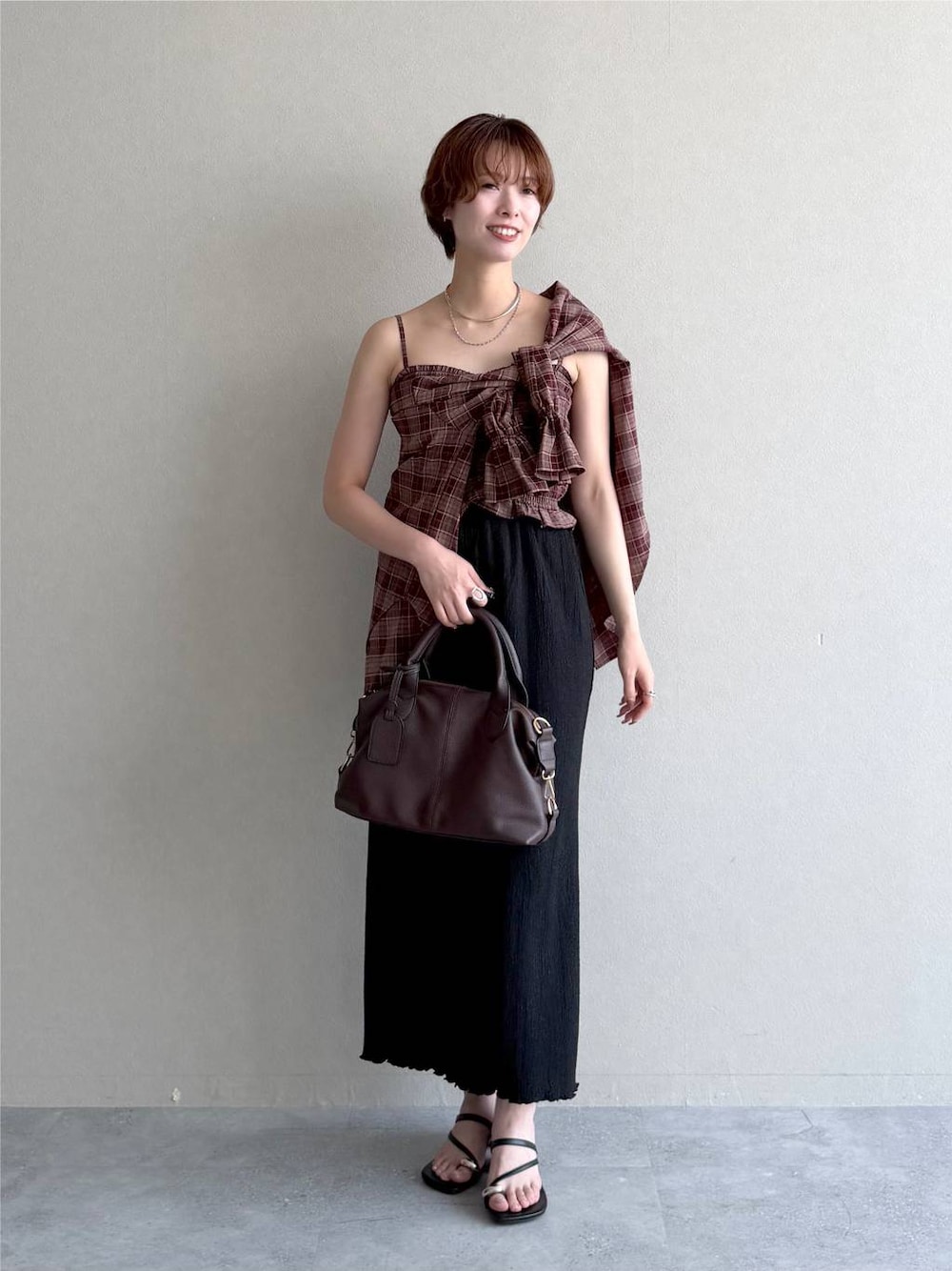ブラック系のスカート、レッド系のシャツ/ブラウス、ブラウン系のボストンバッグを着用したレディースの夏コーディネートの1枚目の写真