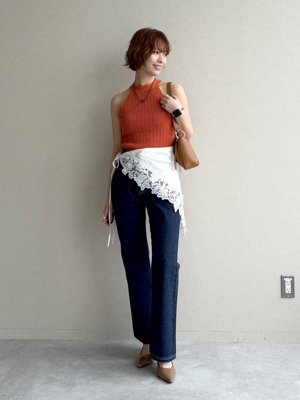 ブルー系のデニムパンツ、ブラウン系のサンダル、イエロー系のショルダーバッグを着用したレディースの春コーディネートの1枚目の写真