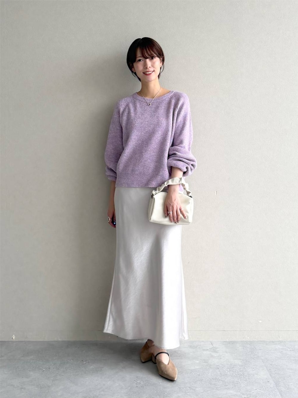 ベージュ系のサンダル、ホワイト系のスカート、パープル系のニット/セーターを着用したレディースの秋コーディネートの1枚目の写真
