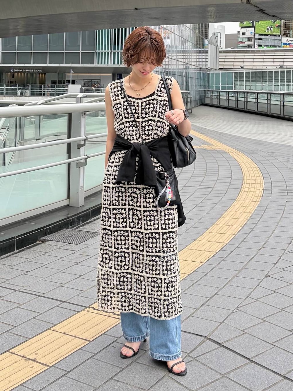 その他のワンピース、ブラック系のハンドバッグ、ブルー系のデニムパンツを着用したレディースの夏コーディネートの1枚目の写真
