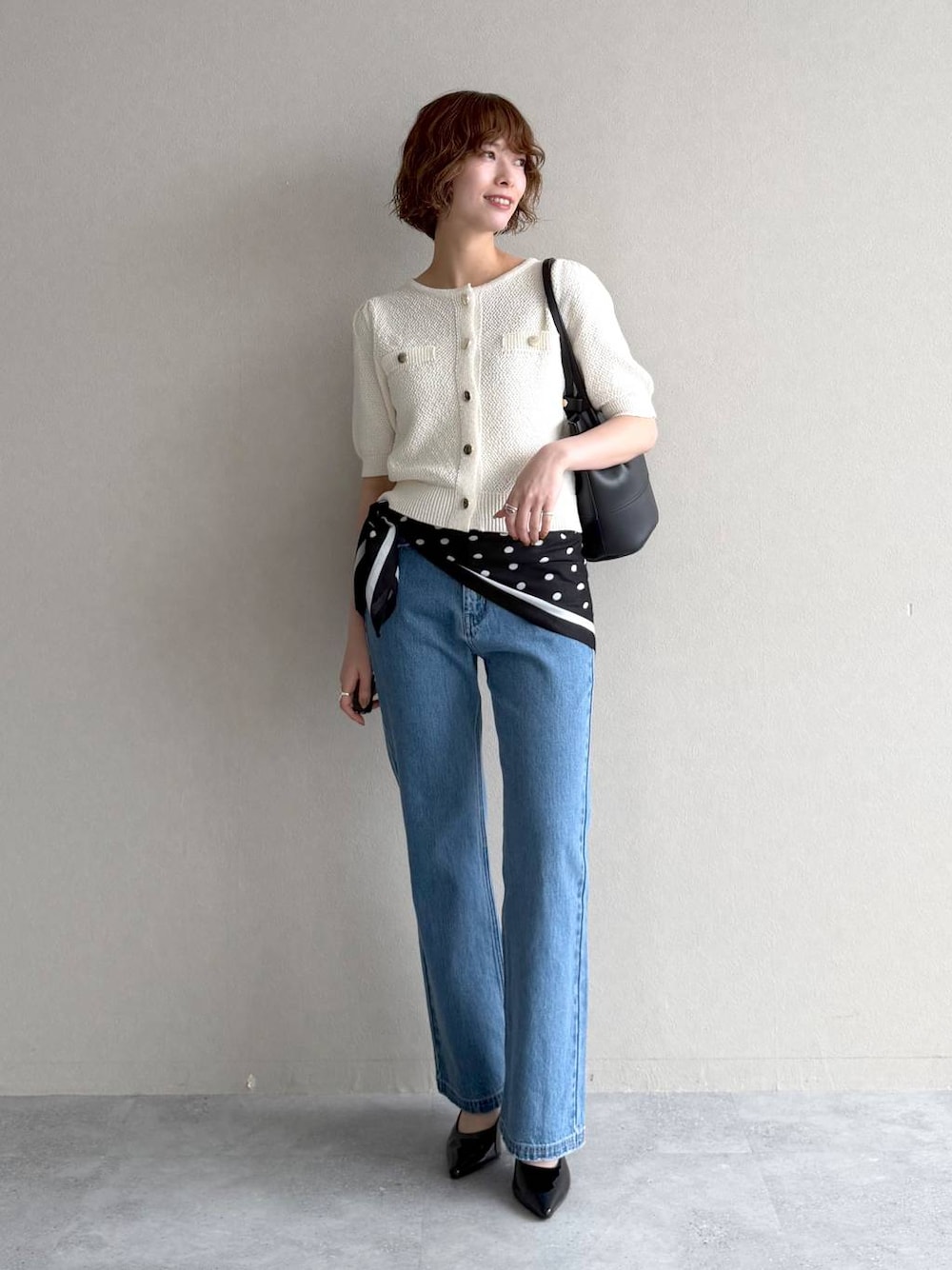 ホワイト系のカーディガン/ボレロ、ブルー系のデニムパンツ、ブラック系のサンダルを着用したレディースの春コーディネートの1枚目の写真