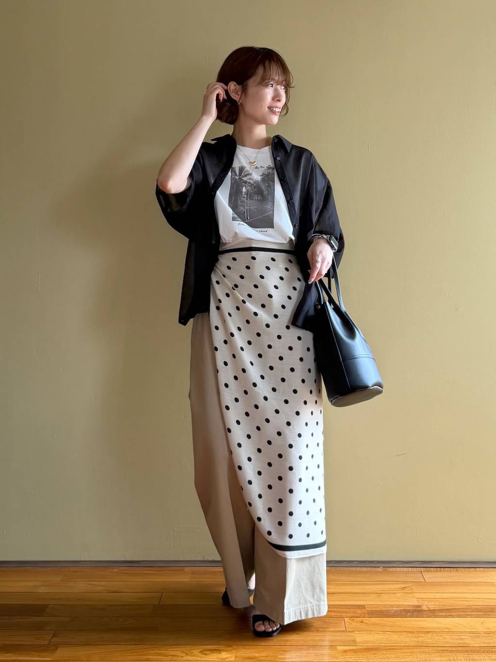 ブラック系のサンダル、ブラック系のシャツ/ブラウス、ベージュ系のチノパンツを着用したレディースの春コーディネートの1枚目の写真