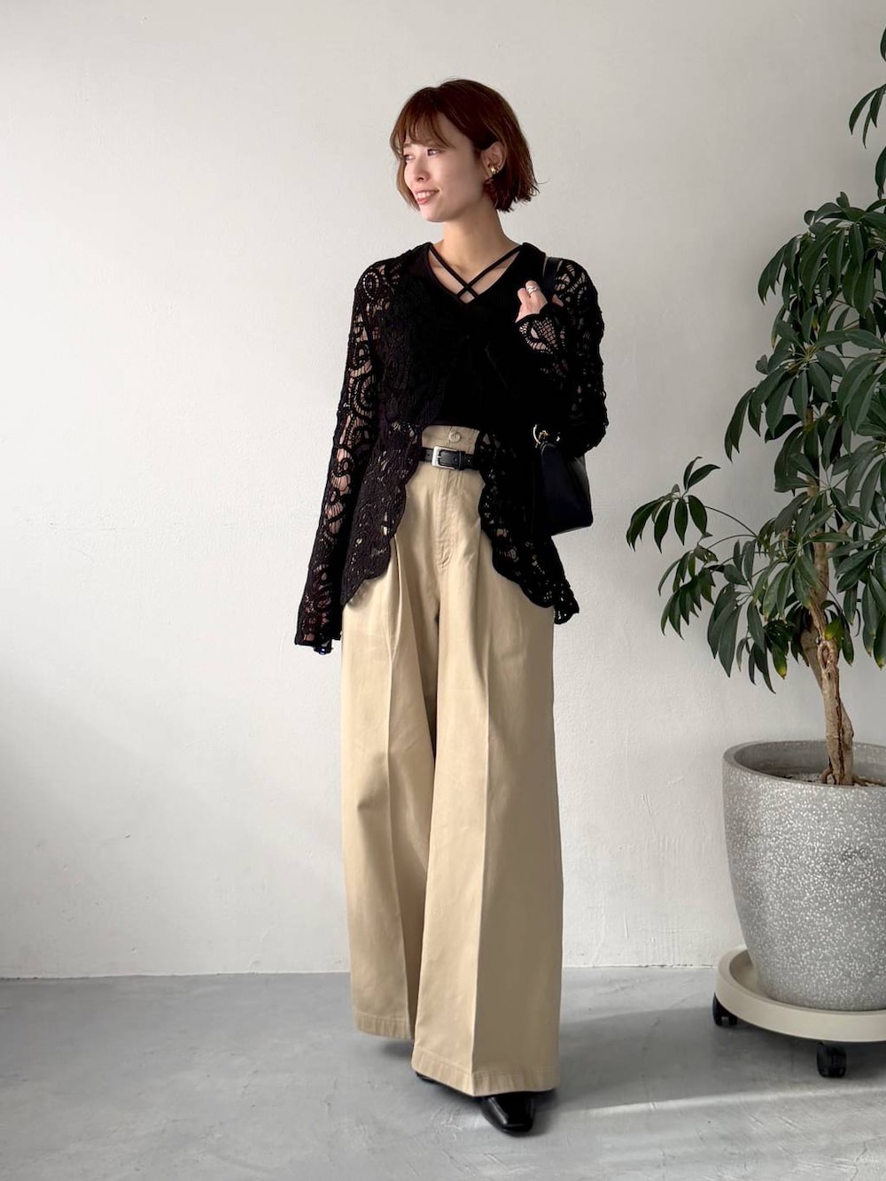 ブラック系のカーディガン/ボレロ、ブラック系のショルダーバッグ、ベージュ系のチノパンツを着用したレディースの春コーディネートの1枚目の写真