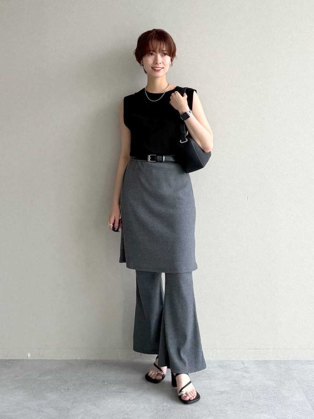 ブラック系のニット/セーター、ブラック系のワンピース、ブラック系のサンダルを着用したレディースの夏コーディネートの1枚目の写真