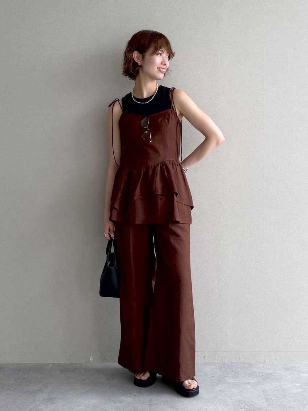 ブラウン系のシャツ/ブラウス、ブラウン系のその他パンツ、ホワイト系のネックレスを着用したレディースの春コーディネートの1枚目の写真