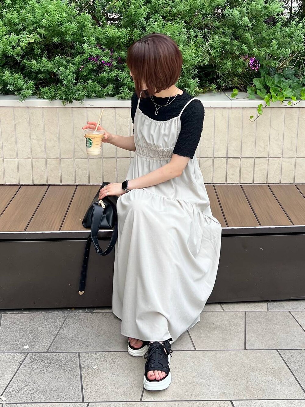 ブラック系のサンダル、ブラック系のTシャツ/カットソー、ブラック系のショルダーバッグを着用したレディースの夏コーディネートの1枚目の写真