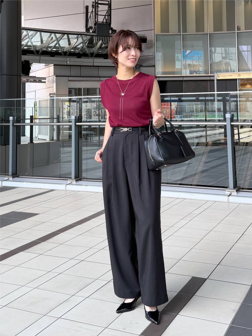 レッド系のニット/セーター、ブラック系のその他パンツ、ブラック系のハンドバッグを着用したレディースの夏コーディネートの1枚目の写真