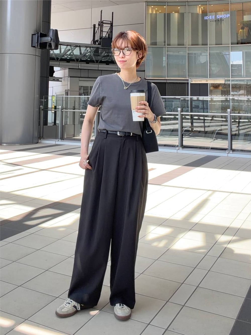 グレー系のTシャツ/カットソー、ブラック系のショルダーバッグ、ブラウン系のサングラスを着用したレディースの夏コーディネートの1枚目の写真