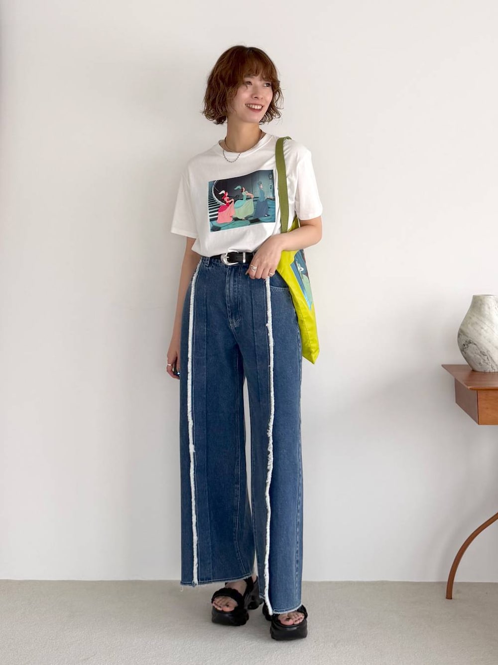 ブルー系のデニムパンツ、ブラック系のサンダル、ブラック系のベルトを着用したレディースの春コーディネートの1枚目の写真