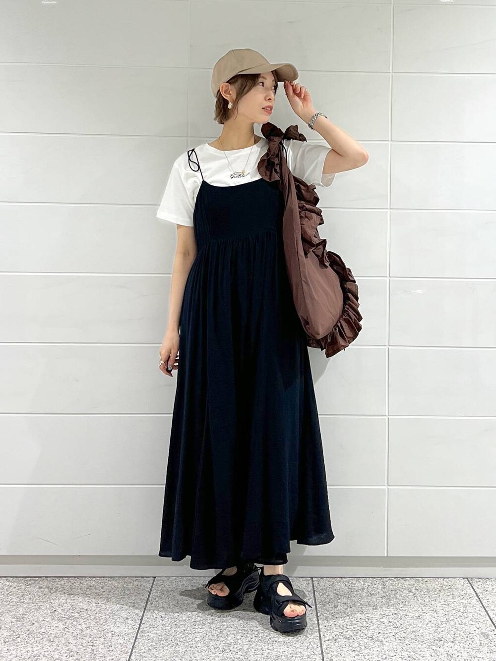 ブラック系のサンダル、ホワイト系のTシャツ/カットソー、ブラック系のワンピースを着用したレディースの春コーディネートの1枚目の写真
