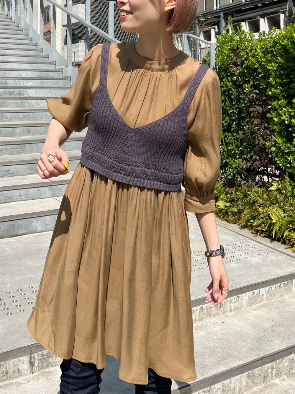 ブルー系のデニムパンツ、ブラック系のサンダル、グレー系のワンピースを着用したレディースの春コーディネートの3枚目の写真