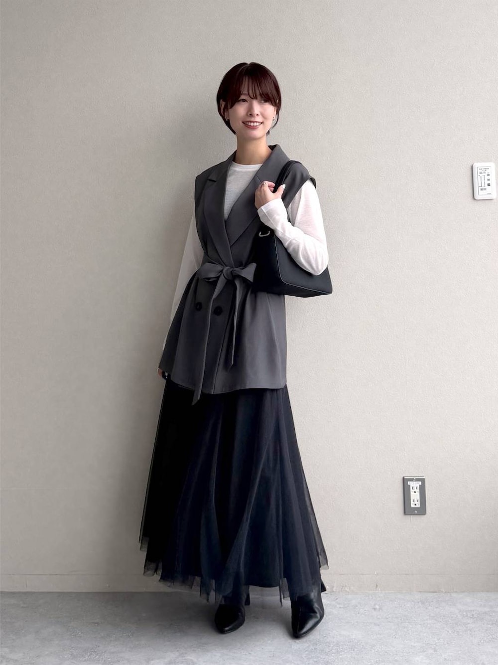 ブラック系のワンピース、ホワイト系のTシャツ/カットソー、ブラック系のショルダーバッグを着用したレディースの秋コーディネートの1枚目の写真