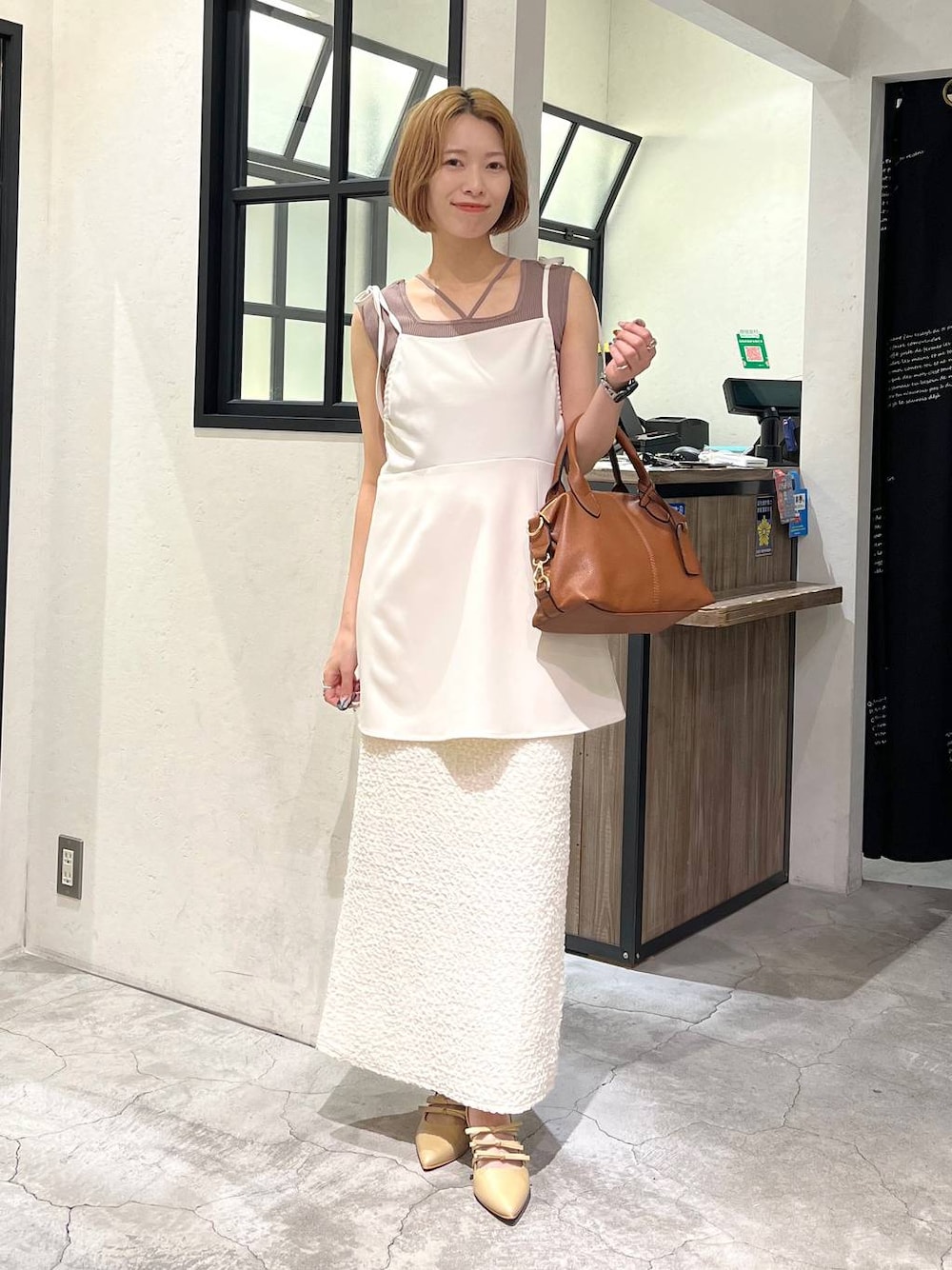 ブラウン系のタンクトップ、ホワイト系のスカート、ゴールド系のパンプスを着用したレディースの夏コーディネートの1枚目の写真