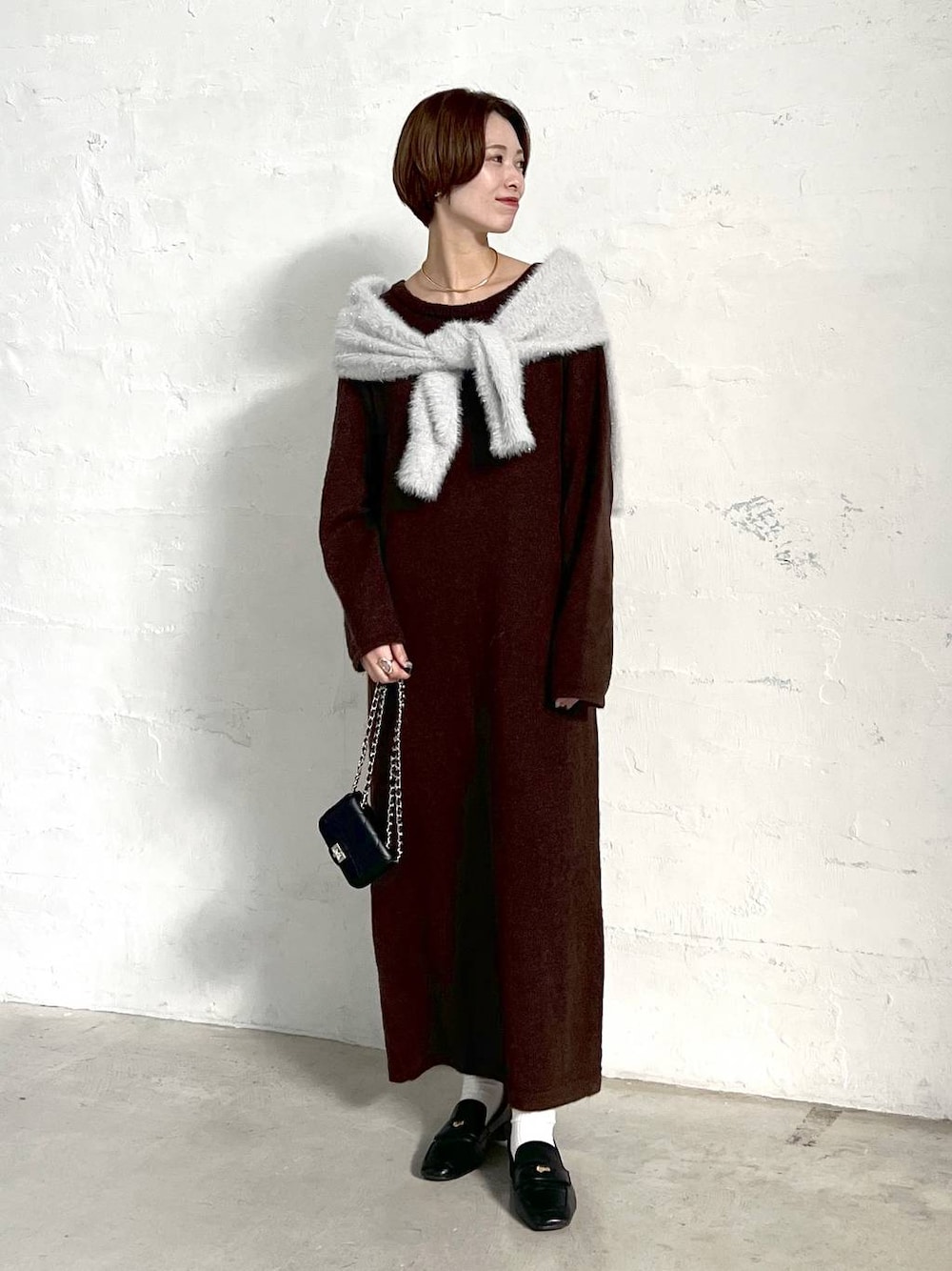 ブラック系のローファー、グレー系のニット/セーター、ブラック系のショルダーバッグを着用したレディースの冬コーディネートの1枚目の写真