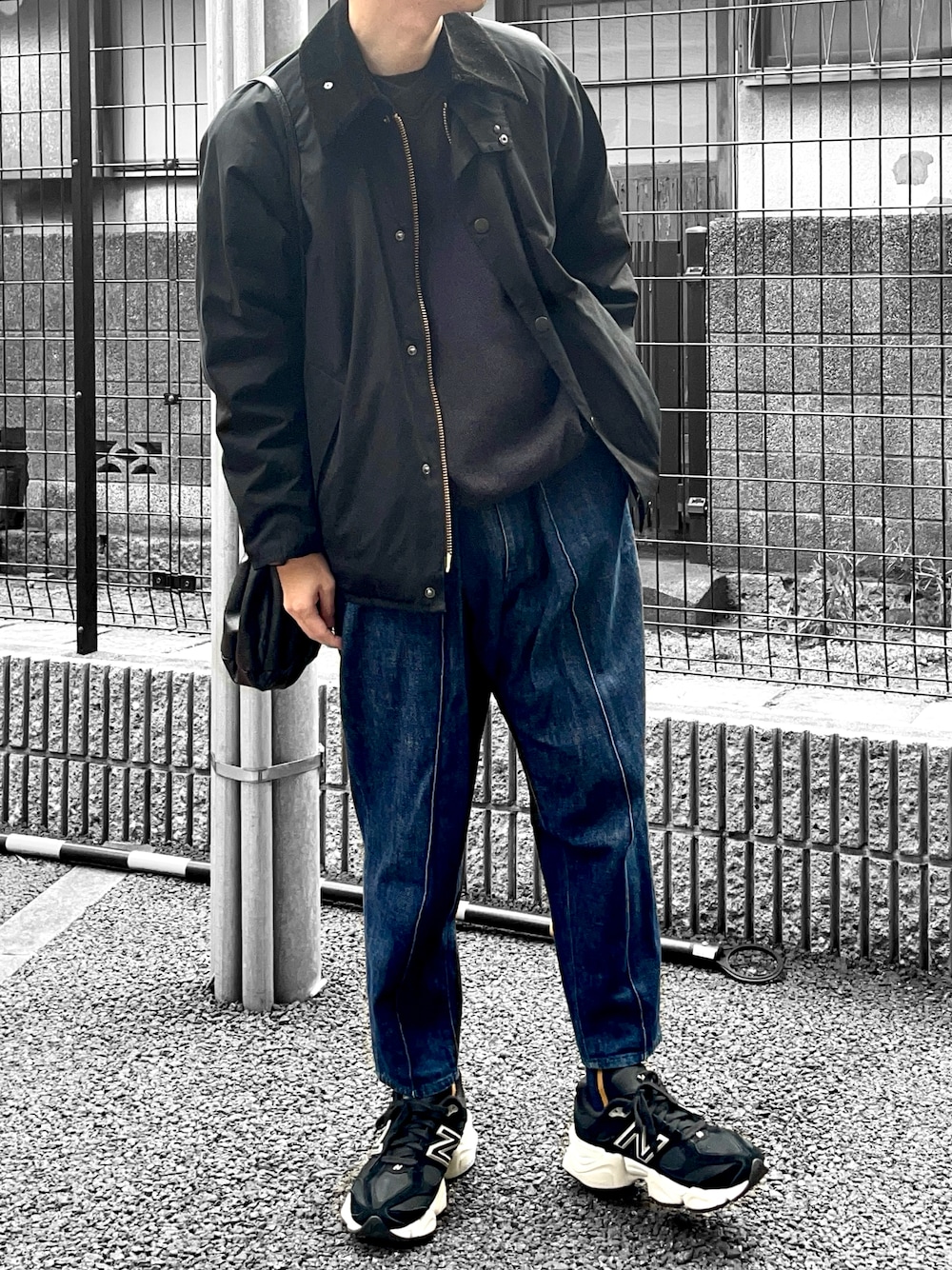 ブラック系のジャケット/アウター、グレー系のニット/セーター、ブルー系のデニムパンツを着用したメンズの春コーディネートの1枚目の写真