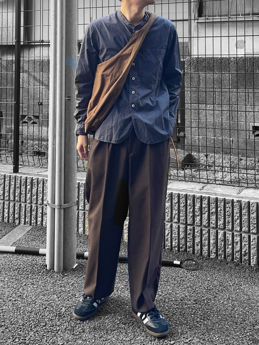 グレー系のシャツ/ブラウス、ブラウン系のバッグ、ブラウン系のスラックスを着用したメンズの春コーディネートの1枚目の写真