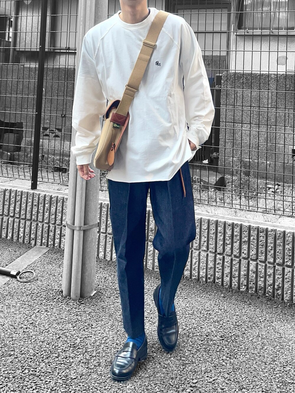 ホワイト系のTシャツ/カットソー、ベージュ系のショルダーバッグ、ブルー系のデニムパンツを着用したメンズの春コーディネートの1枚目の写真