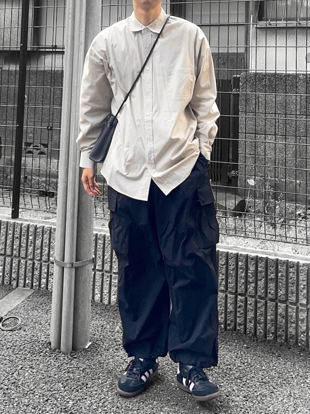 グレー系のシャツ/ブラウス、ブラック系のカーゴパンツ、ブラック系のスニーカーを着用したメンズの春コーディネートの1枚目の写真