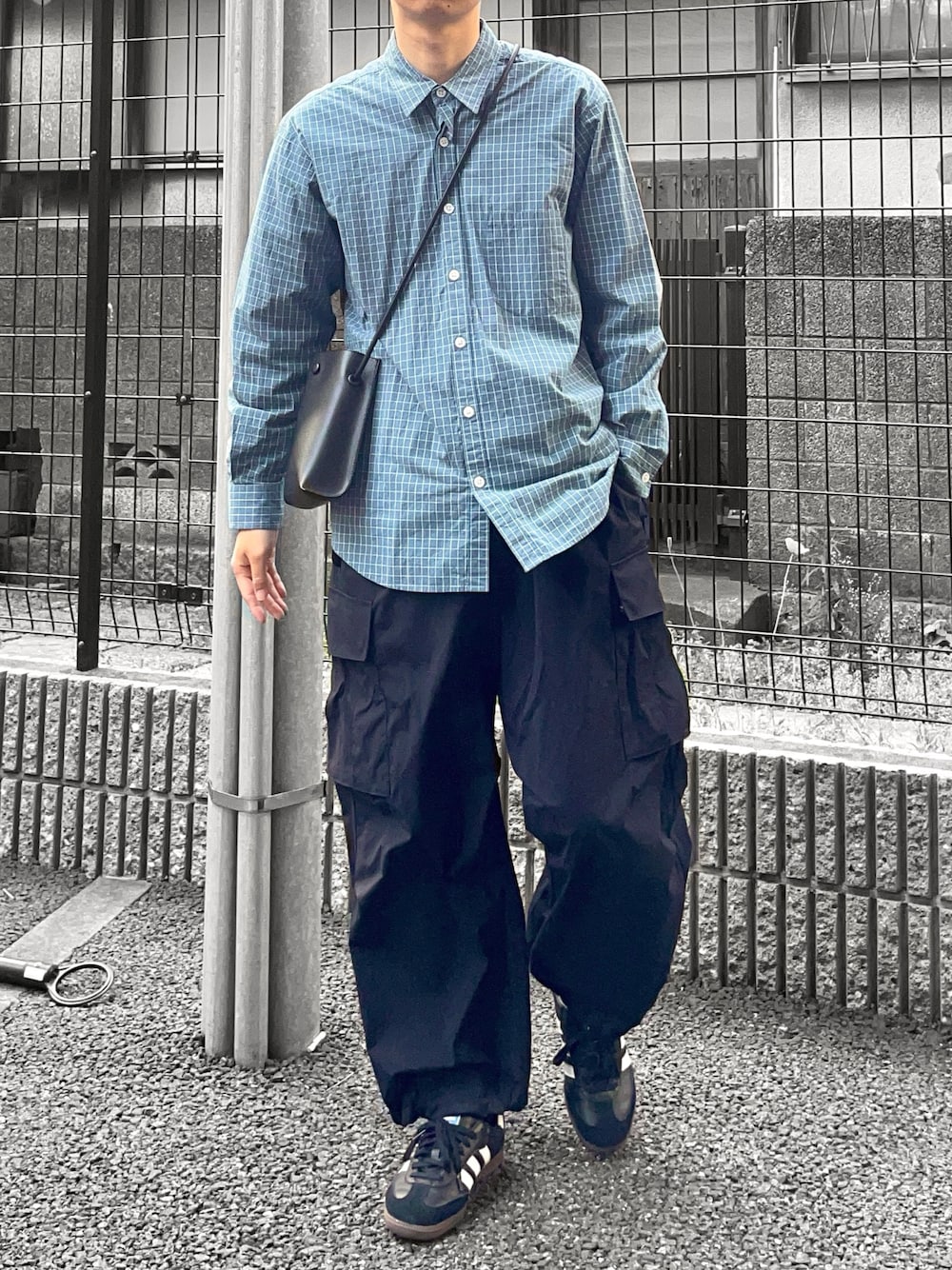 ブルー系のシャツ/ブラウス、ブラック系のカーゴパンツ、ブラック系のスニーカーを着用したメンズの春コーディネートの1枚目の写真