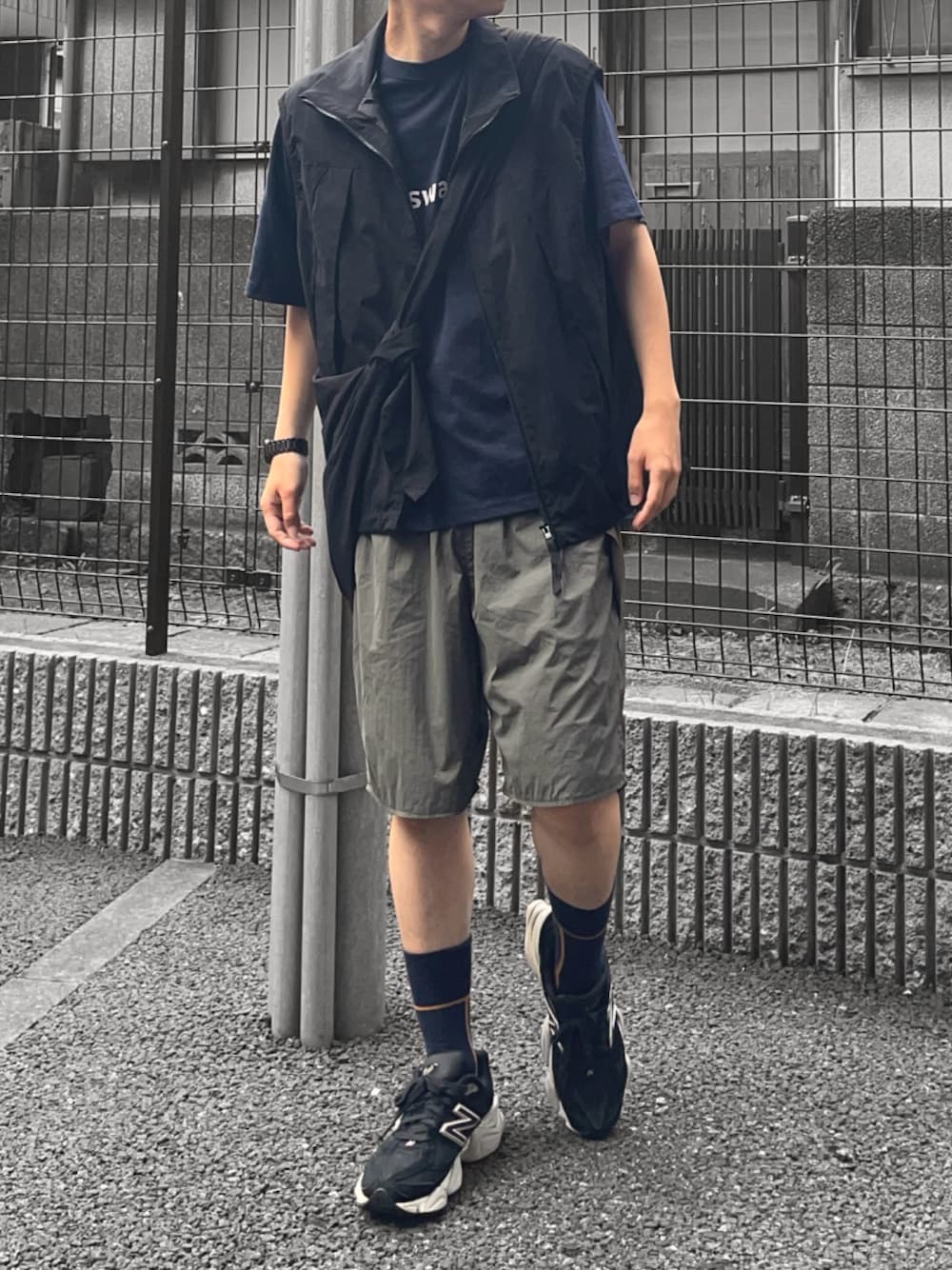 ブルー系のTシャツ/カットソー、ブラック系のベスト、ブラック系のショルダーバッグを着用したメンズの夏コーディネートの1枚目の写真