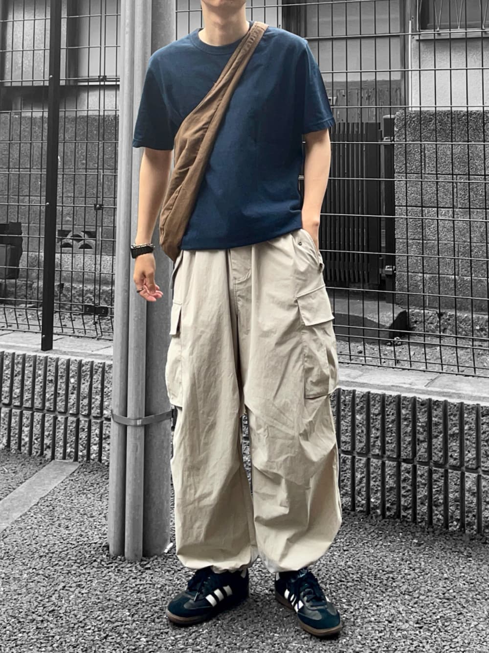 ブルー系のTシャツ/カットソー、ブラウン系のバッグ、グレー系のカーゴパンツを着用したメンズの夏コーディネートの1枚目の写真