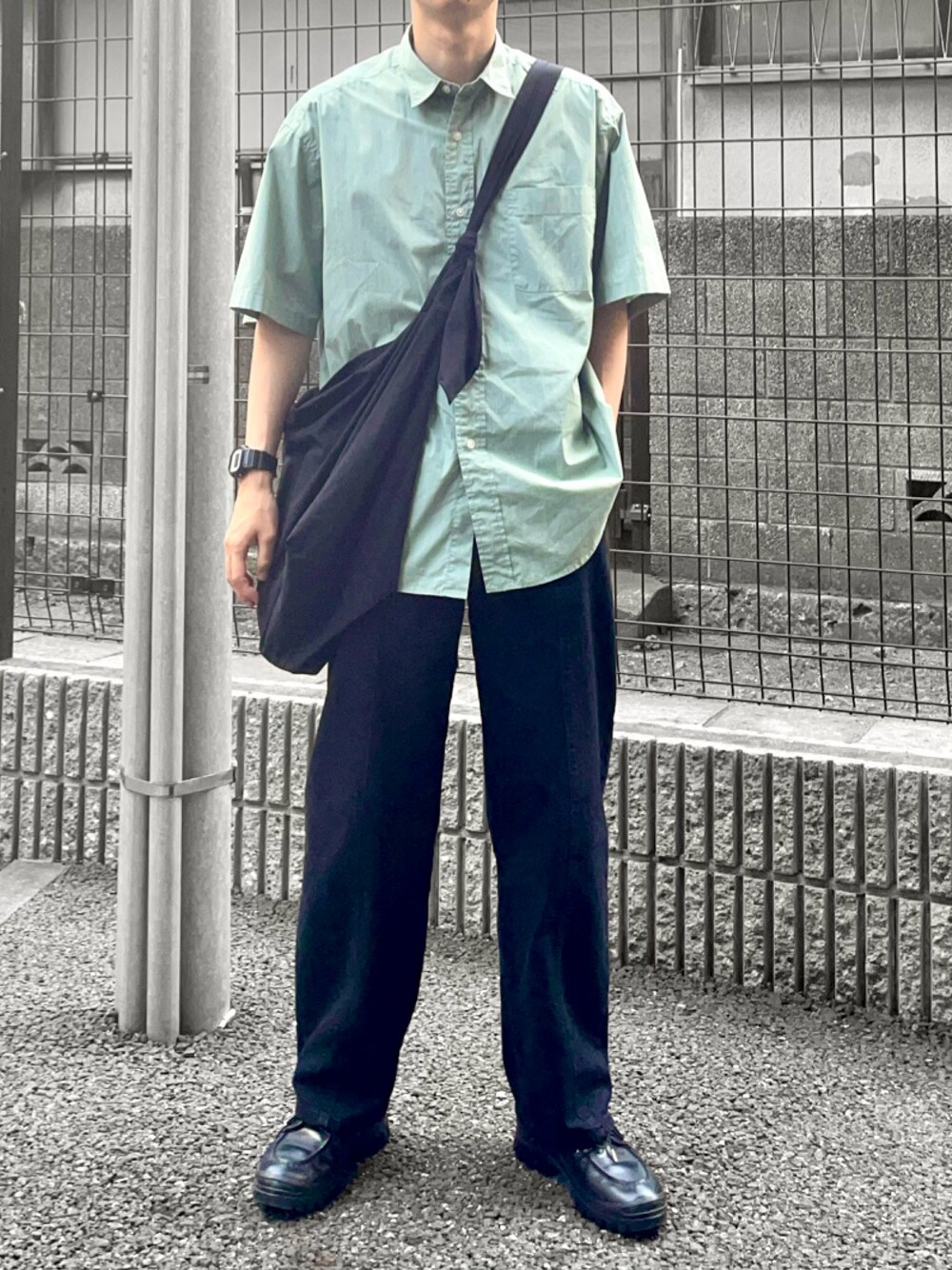 ブラック系のショルダーバッグ、ブラック系のデニムパンツ、ブラック系のドレスシューズを着用したメンズの春コーディネートの1枚目の写真
