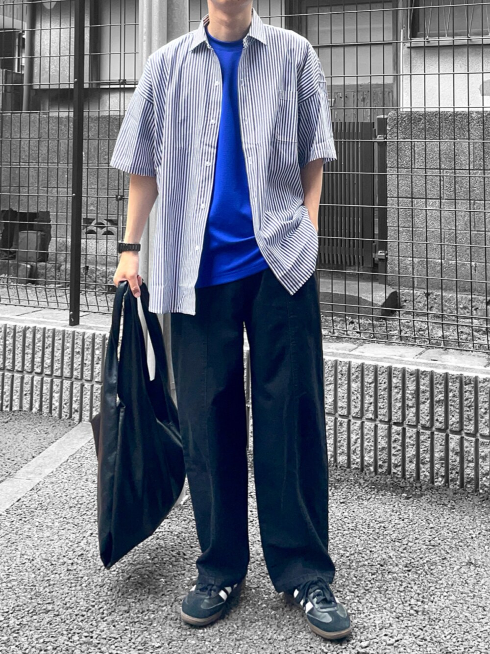 ブラック系のシャツ/ブラウス、ブラック系のトートバッグ、ブラック系のデニムパンツを着用したメンズの春コーディネートの1枚目の写真