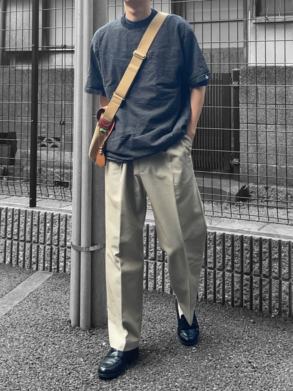 ブラック系のTシャツ/カットソー、ベージュ系のショルダーバッグ、ベージュ系のスラックスを着用したメンズの夏コーディネートの1枚目の写真