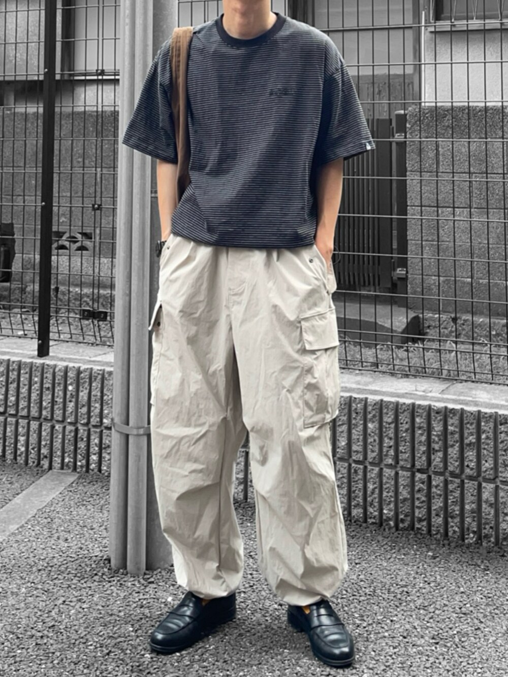 ブラック系のTシャツ/カットソー、ブラウン系のバッグ、グレー系のカーゴパンツを着用したメンズの夏コーディネートの1枚目の写真