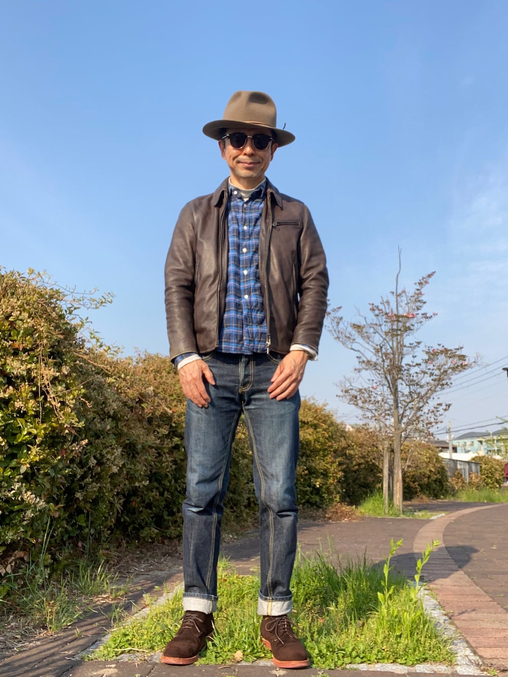 「襟付きライダースジャケット、ネルシャツ、ハイネックカットソー、KAKEYA JEANS、スエードシューズ、中折れハット、アズーロ・エ・マローネ」｜「KAKEYAのアイテム（デニムパンツ、ブルー系）」を使った、Paulさん（メンズ・171cm）の春コーディネートの1枚目の写真