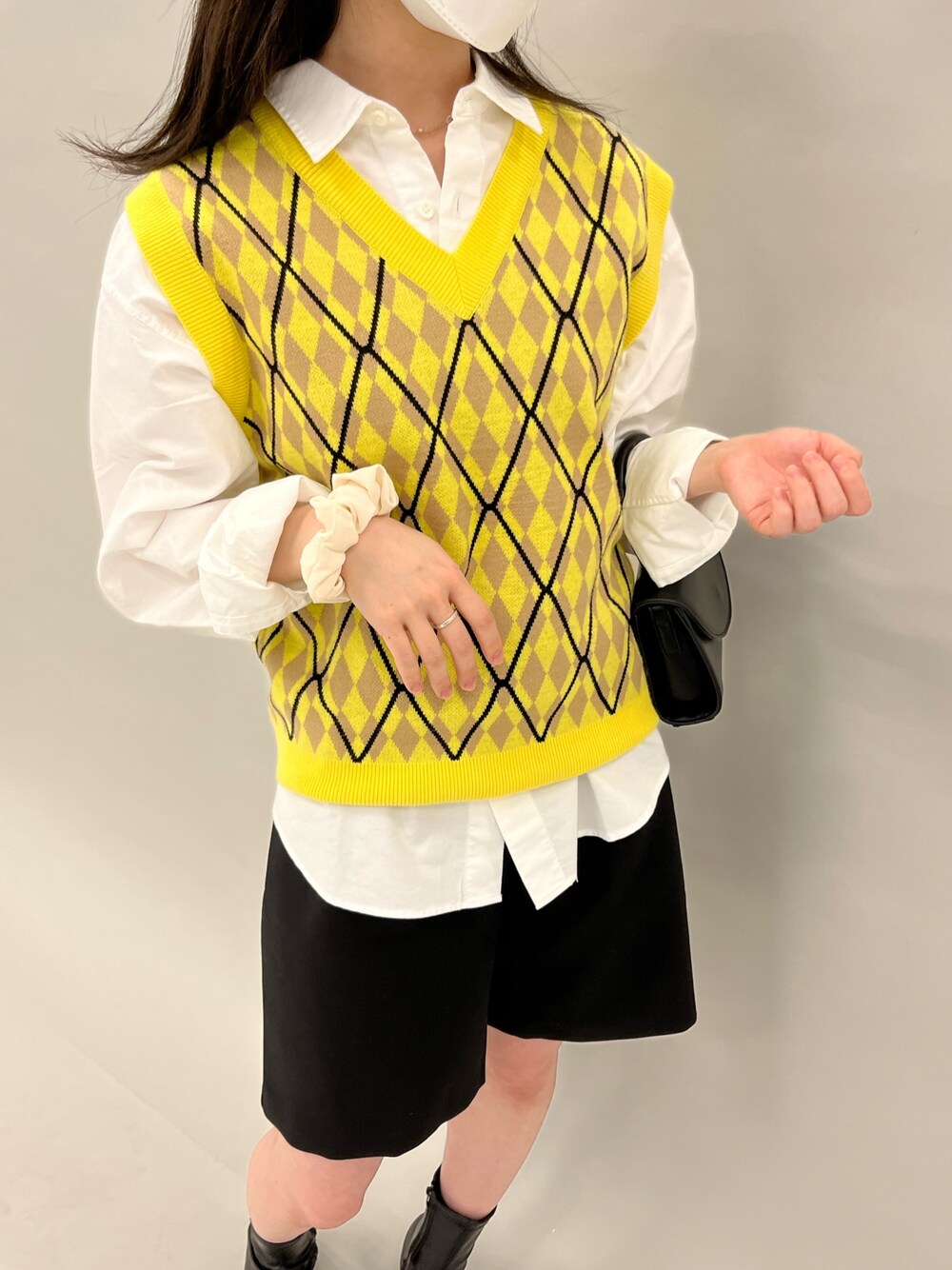 ブラック系のその他パンツ、イエロー系のベスト、ホワイト系のシャツ/ブラウスを着用したレディースの春コーディネートの2枚目の写真