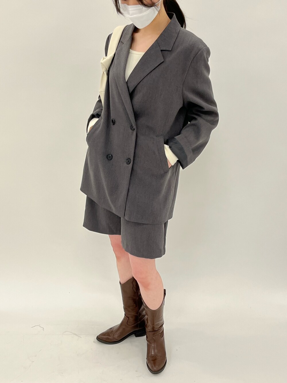 グレー系のテーラードジャケット、グレー系のその他パンツ、ベージュ系のハンドバッグを着用したレディースの春コーディネートの4枚目の写真