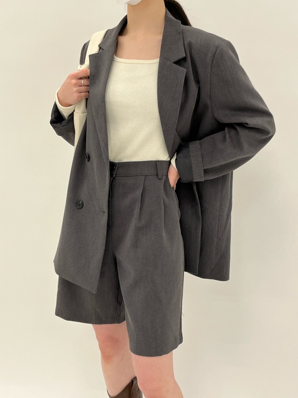 グレー系のテーラードジャケット、グレー系のその他パンツ、ベージュ系のハンドバッグを着用したレディースの春コーディネートの3枚目の写真