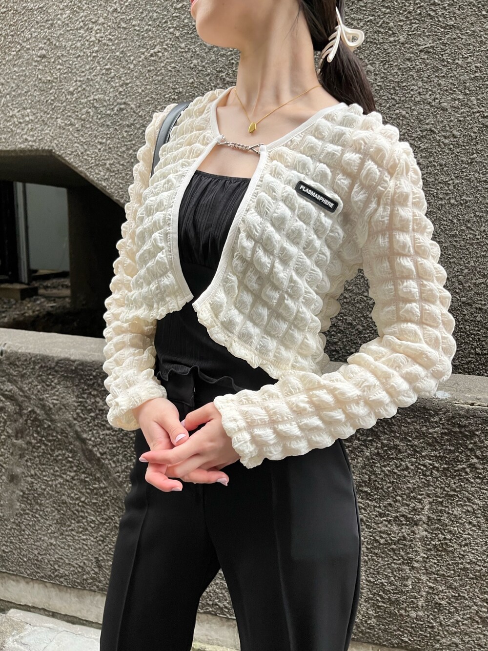 ブラック系のスラックス、ブラック系のキャミソール、ホワイト系のカーディガン/ボレロを着用したレディースの夏コーディネートの2枚目の写真