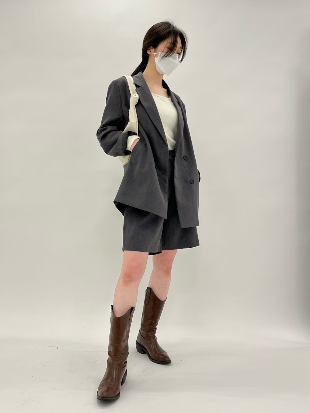 グレー系のテーラードジャケット、グレー系のその他パンツ、ベージュ系のハンドバッグを着用したレディースの春コーディネートの2枚目の写真
