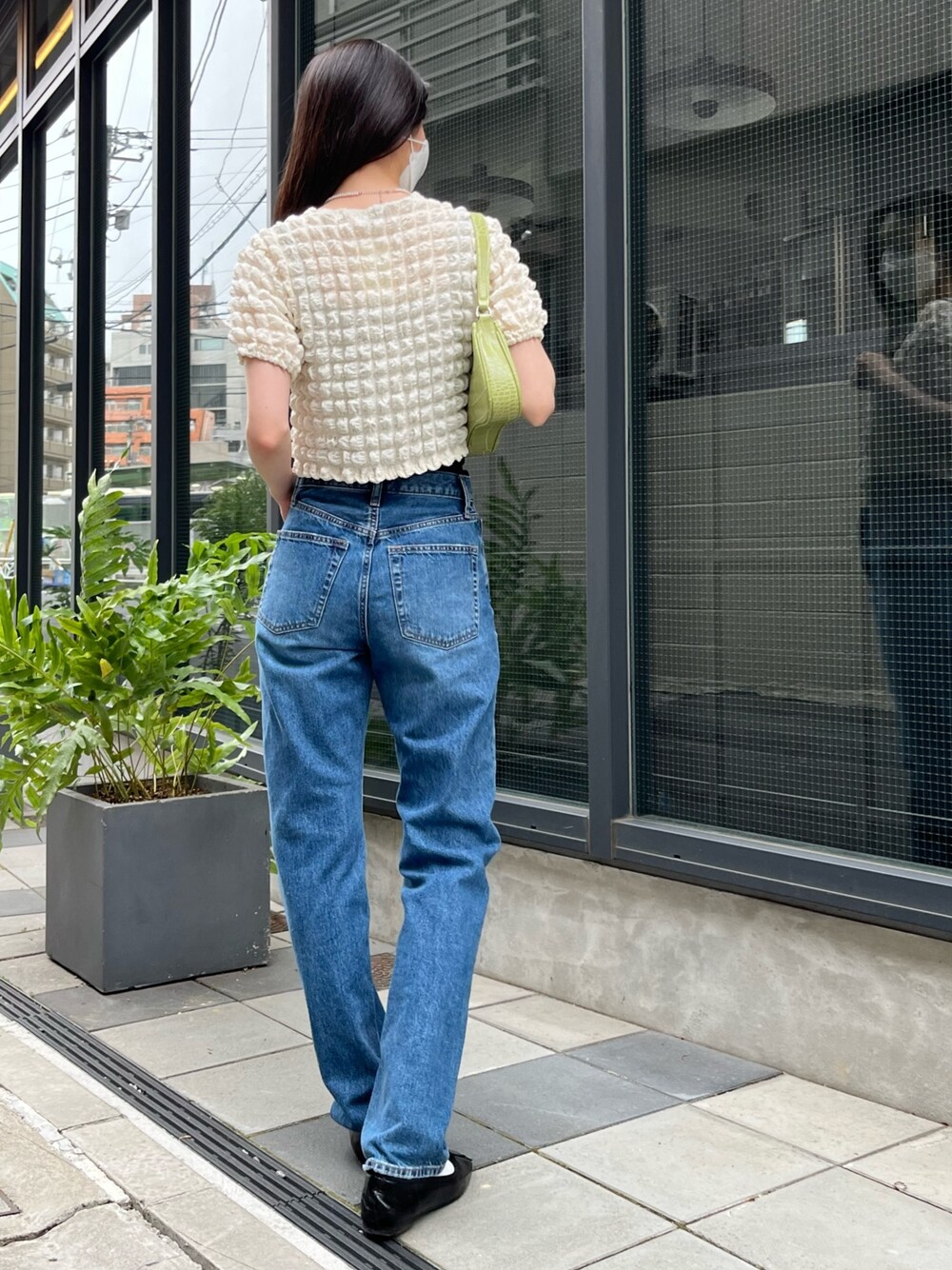 ベージュ系のTシャツ/カットソー、ブルー系のデニムパンツ、ブラック系のバレエシューズを着用したレディースの夏コーディネートの2枚目の写真