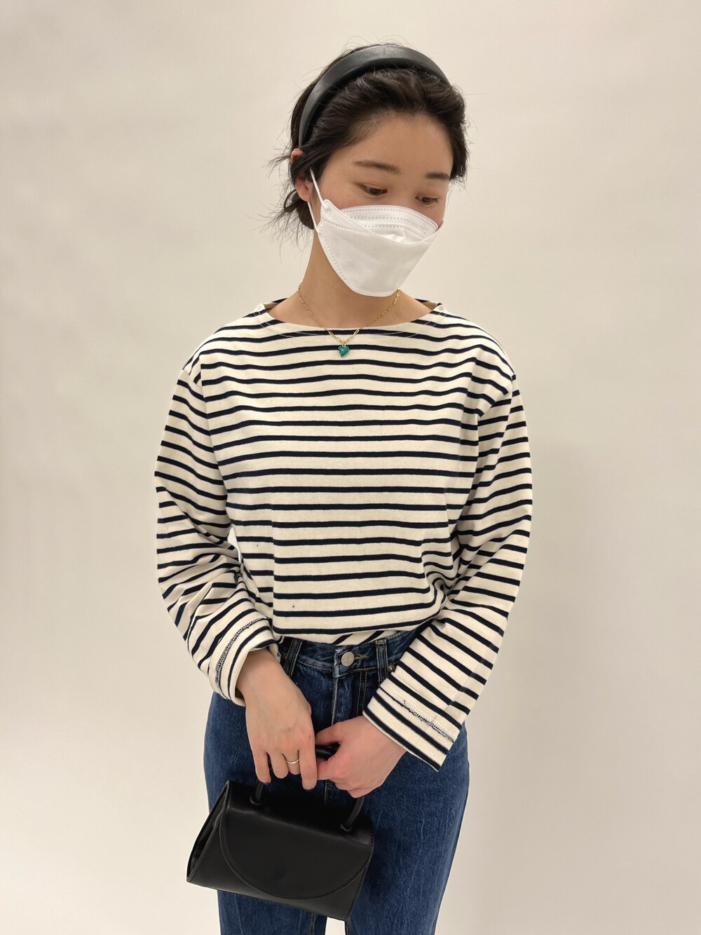 ベージュ系のTシャツ/カットソー、ブルー系のデニムパンツ、グリーン系のパンプスを着用したレディースの冬コーディネートの4枚目の写真