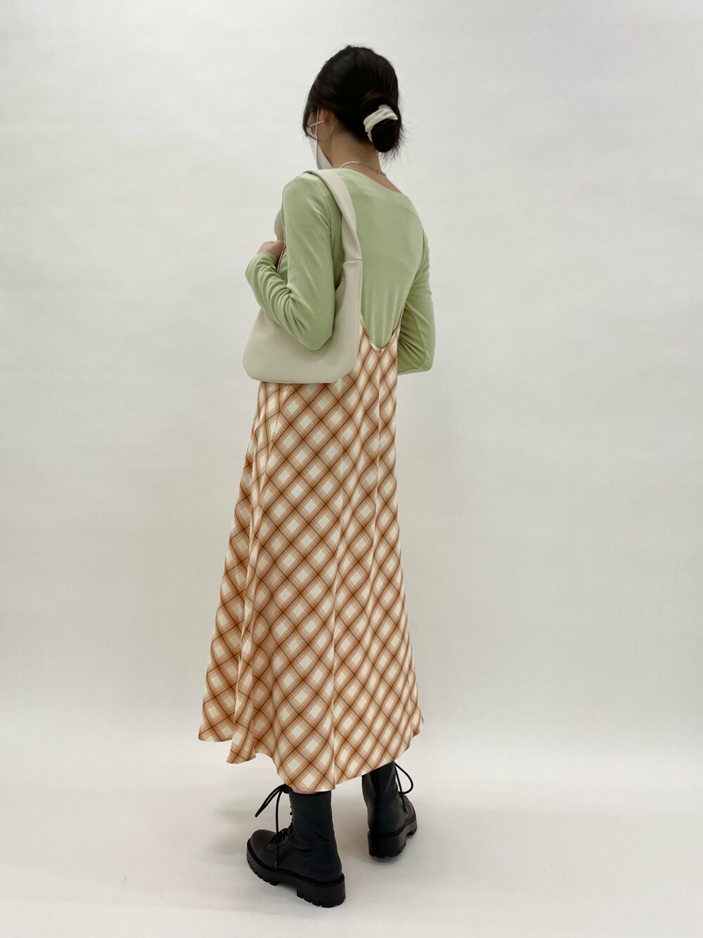 オレンジ系のワンピース、グリーン系のTシャツ/カットソー、ベージュ系のハンドバッグを着用したレディースの春コーディネートの2枚目の写真