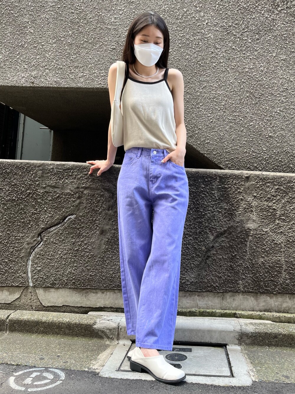 パープル系のデニムパンツ、ベージュ系のキャミソール、ホワイト系のシューズを着用したレディースの夏コーディネートの2枚目の写真