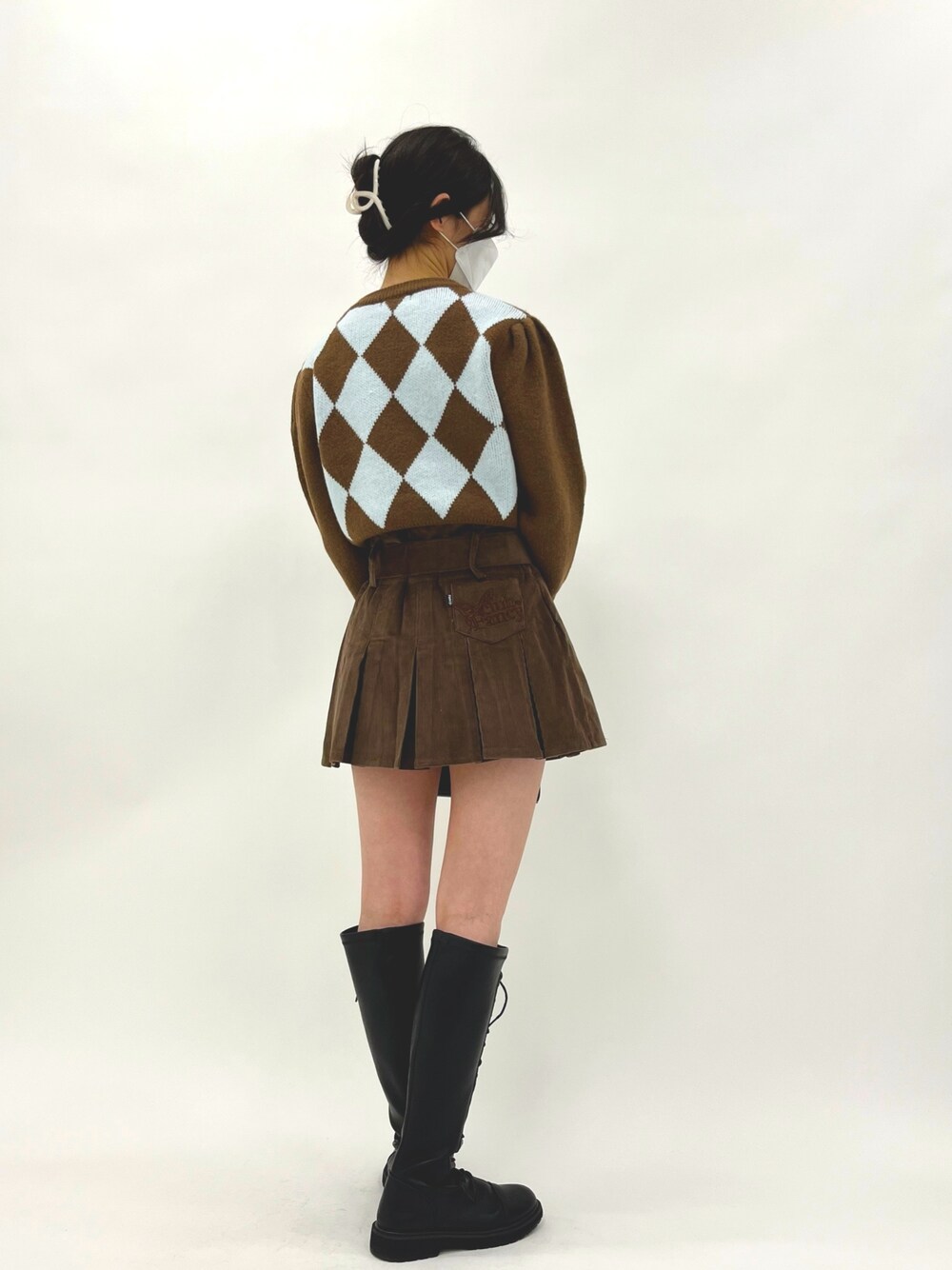 ブラウン系のスカート、ブラウン系のニット/セーター、ブラック系のショルダーバッグを着用したレディースの冬コーディネートの3枚目の写真