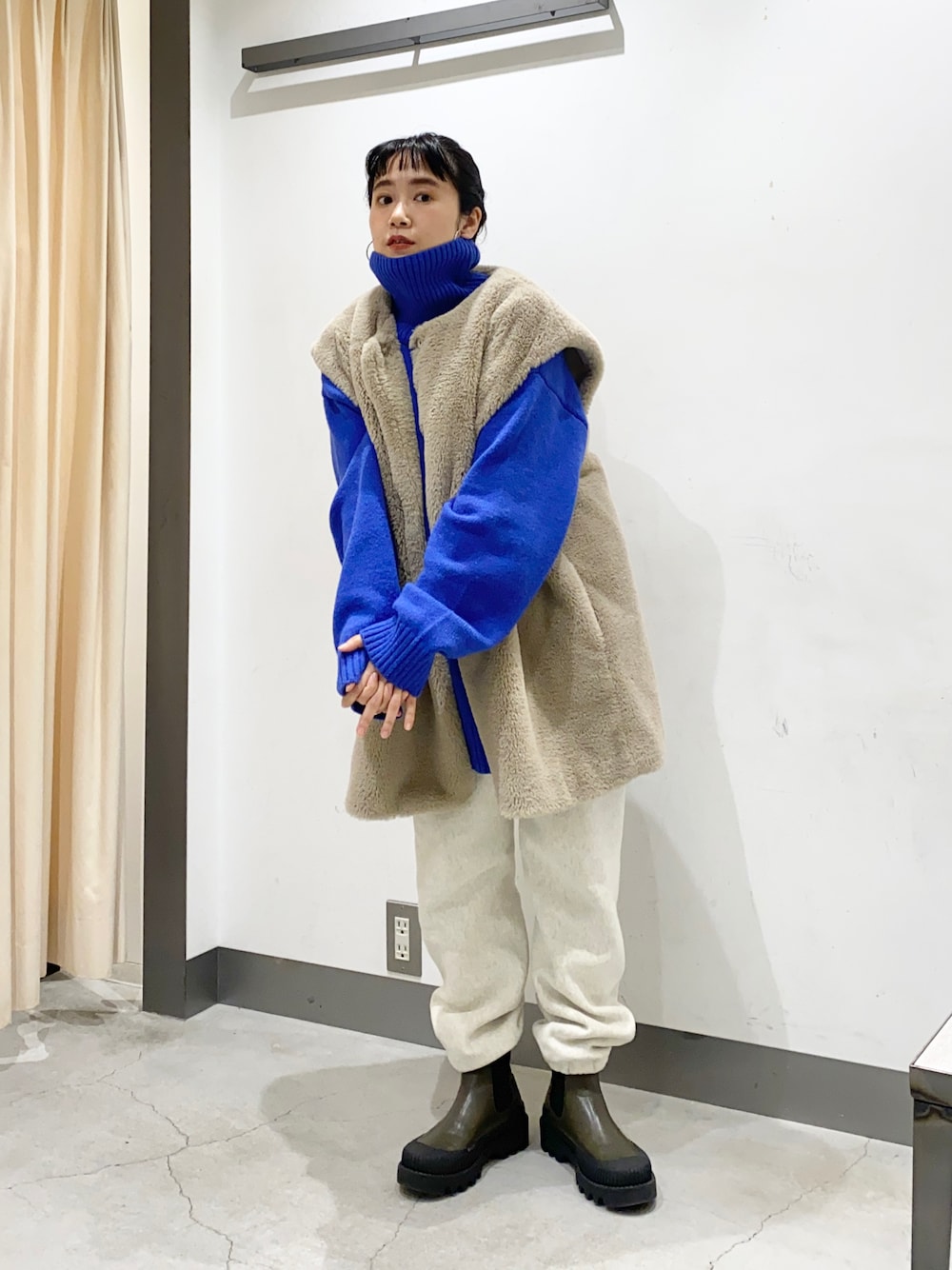 ブルー系のニット/セーター、ベージュ系のジャケット/アウター、ホワイト系のパンツを着用したレディースの冬コーディネートの1枚目の写真