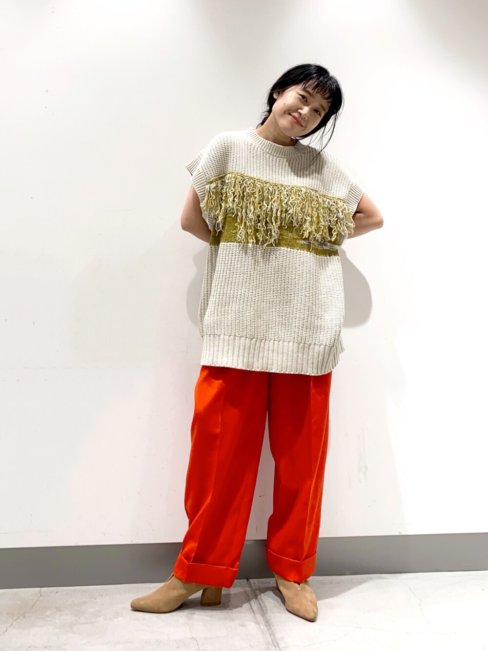 グレー系のベスト、レッド系のその他パンツ、ブラウン系のブーツを着用したレディースの秋コーディネートの1枚目の写真