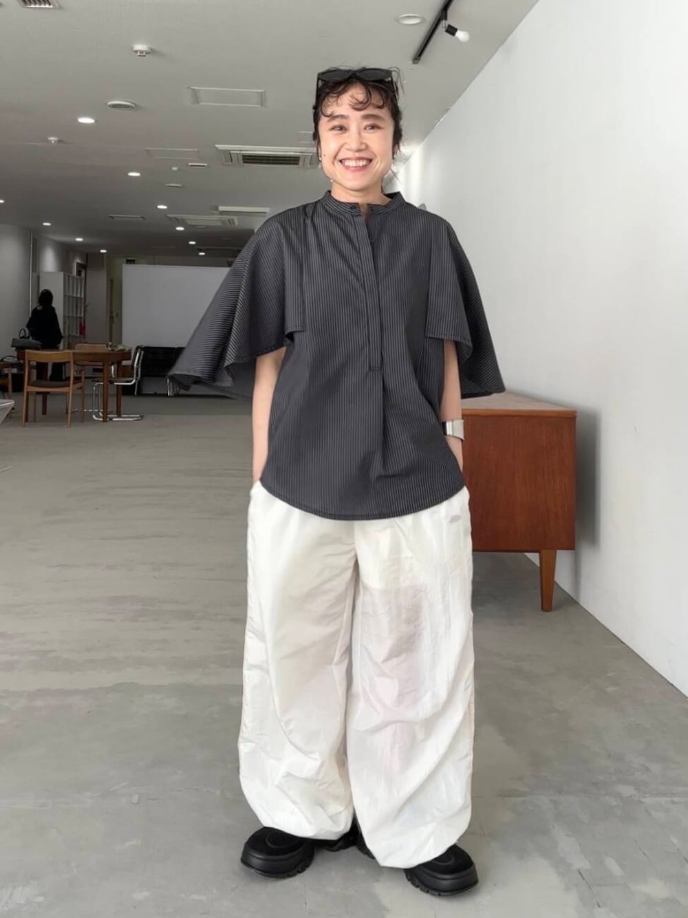 ホワイト系のその他パンツ、グレー系のシャツ/ブラウス、ブラック系のスニーカーを着用したレディースの夏コーディネートの1枚目の写真