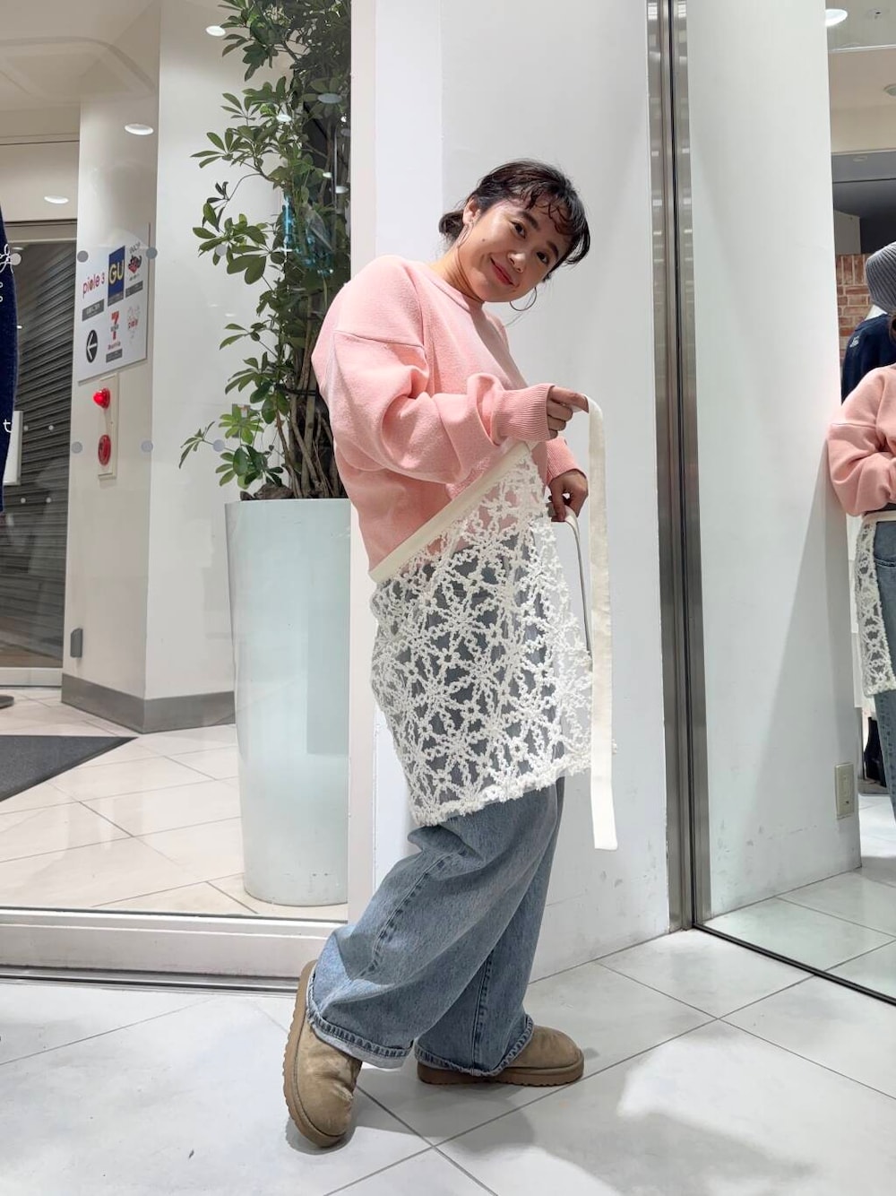 ブルー系のデニムパンツ、ホワイト系のスカート、ピンク系のニット/セーターを着用したレディースの冬コーディネートの1枚目の写真