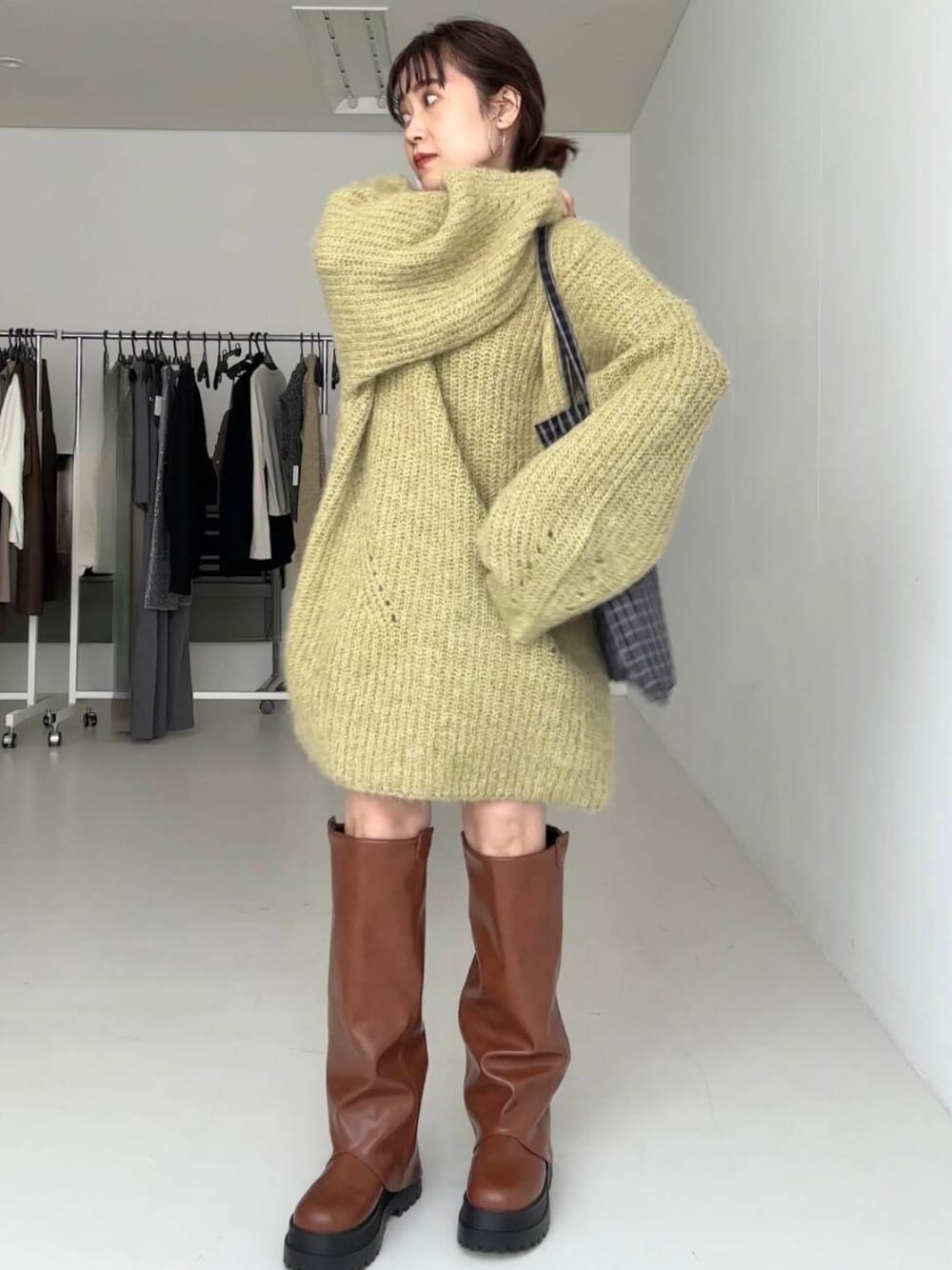 グリーン系のワンピース、ブラウン系のブーツを着用したレディースの秋コーディネートの1枚目の写真