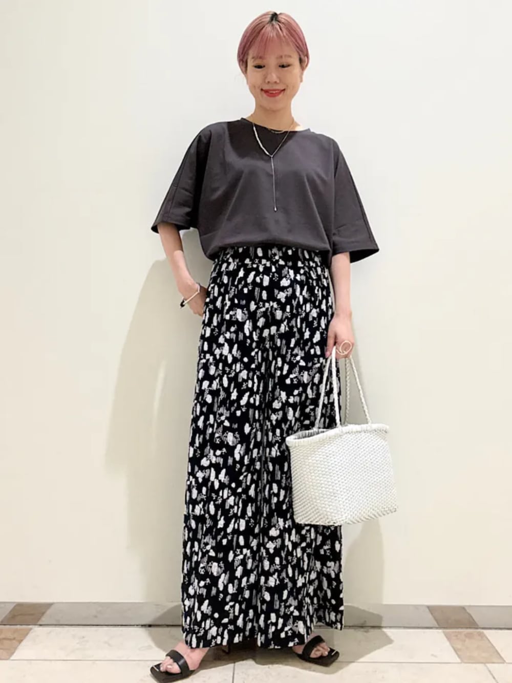 ホワイト系のトートバッグ、グレー系のTシャツ/カットソー、ゴールド系のネックレスを着用したレディースの夏コーディネートの1枚目の写真