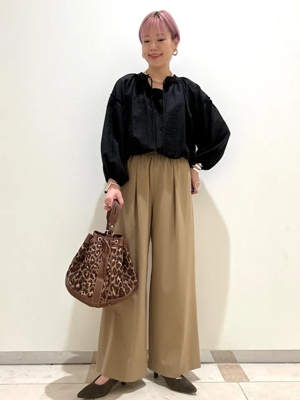 ベージュ系のその他パンツ、ブラウン系のパンプス、ブラック系のシャツ/ブラウスを着用したレディースの秋コーディネートの1枚目の写真