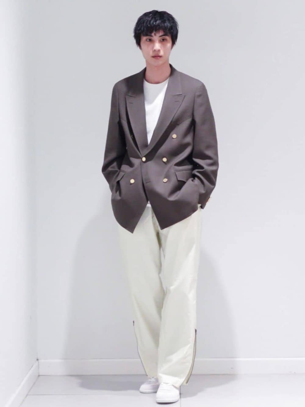 ブラウン系のテーラードジャケット、ホワイト系のカーゴパンツを着用したメンズの冬コーディネートの1枚目の写真